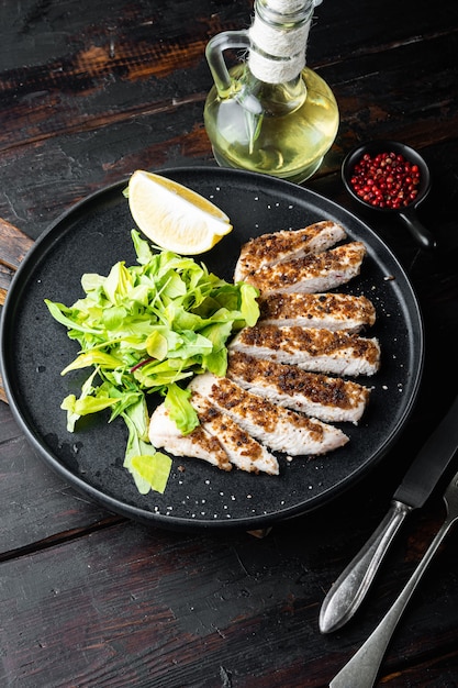 Crumbed, chicken breast fillet grilled, on wooden table