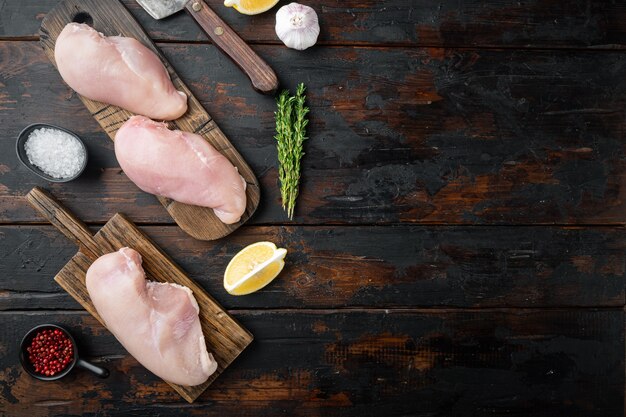 Crumbed uncooked chicken breasts ingredient, on dark wooden table, top view