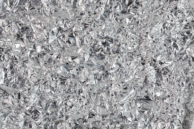 Photo crumpled aluminium foil flat background and texture