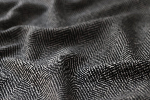 Photo crumpled black herringbone suit fabric with white stripes for sale in clothing store soft