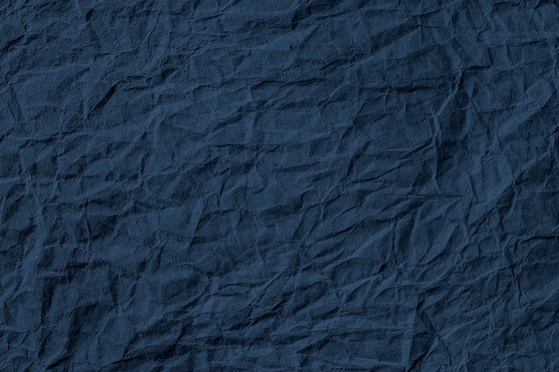 Crumpled dark blue paper textured background