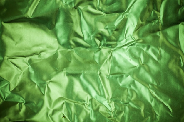 しわくちゃの緑のアルミホイルの背景。