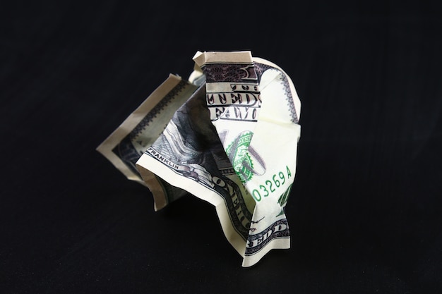 Crumpled one hundred American dollar. The collapse of the dollar. Devaluation. Falling currency.