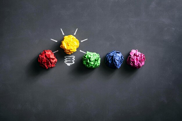 Photo crumpled paper balls on blackboard idea concept background