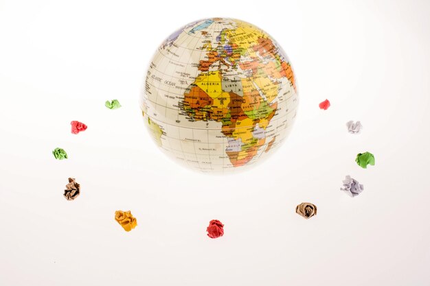 Crumpled papers form a round shape around a globe