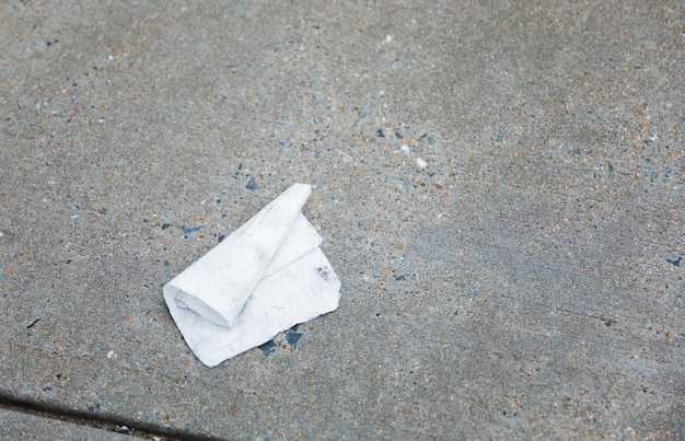 A crumpled piece of paper is on the ground