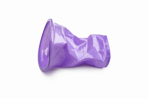 Photo crumpled purple, plastic cup isolated on white. the concept of ecology and recycling.