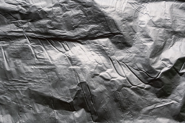 Crumpled and shiny silver paper background Crumpled foil texture