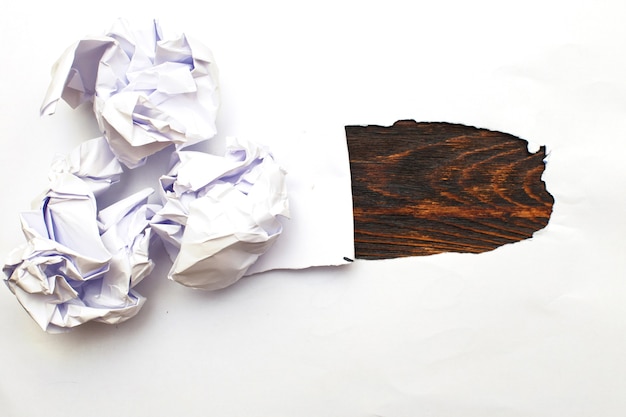 Crumpled up papers with a sheet of blank paper on wooden background