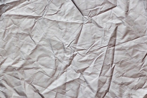 Photo crumpled white cloth with creases casting shadows as background