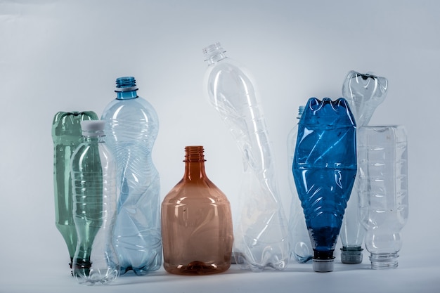 Crumples various water bottles standing in a row and accenting attention on environmental problems