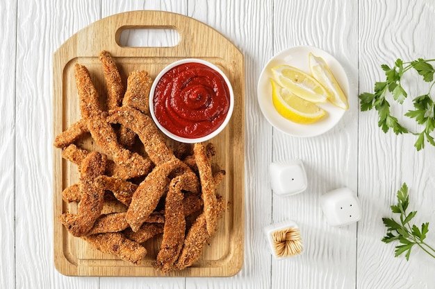 Crunchy Baked Chicken Tenders on a wooden board