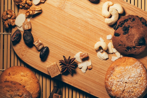 Crunchy chocolate cookies with nuts, cocoa chips and spices on cutting board