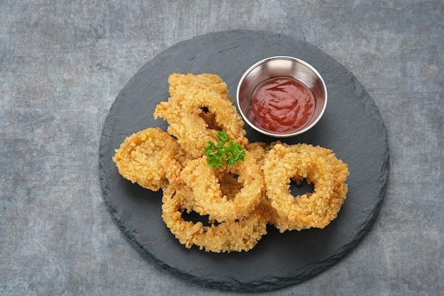 Crunchy fried onion rings with tomato sauce