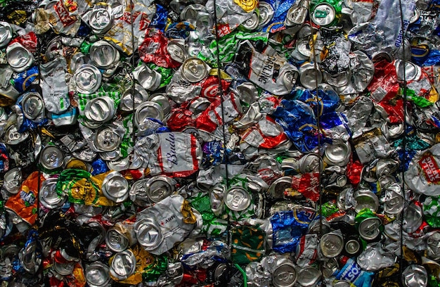 Photo crushed aluminium cans in recycling bales textured environmental background