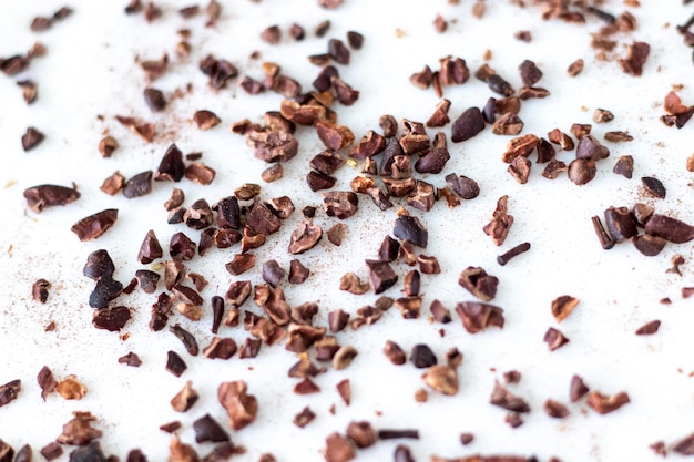 Crushed cacao beans on white background Selective focus