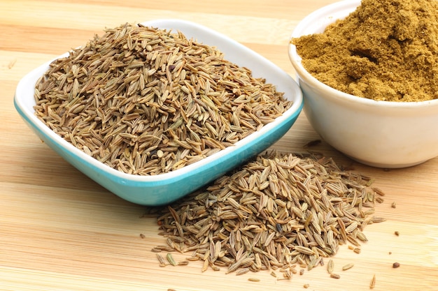 Crushed cumin on wooden background