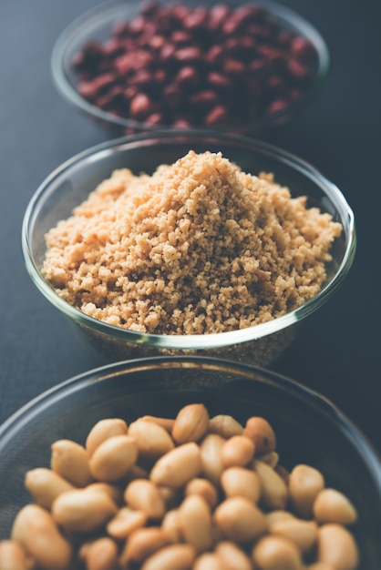 Crushed peanuts or mungfali powder with whole and roasted groundnut. Served in a bowl over moody background. Selective focus