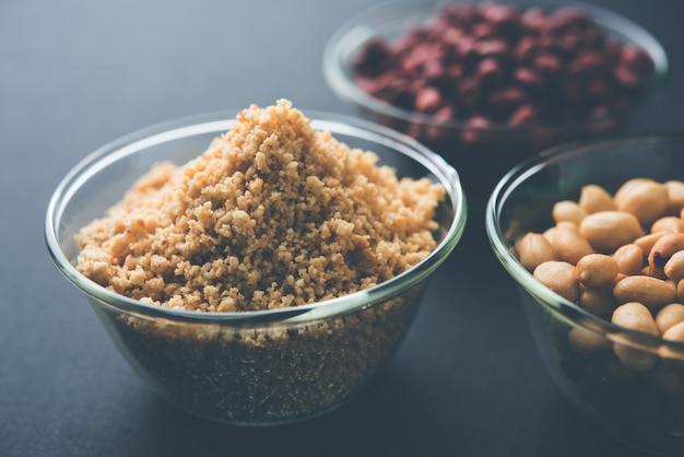 Crushed peanuts or mungfali powder with whole and roasted groundnut. Served in a bowl over moody background. Selective focus