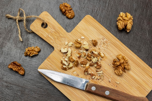 Crushed walnuts and knife on cutting board Walnut shell and walnut kernels on the table