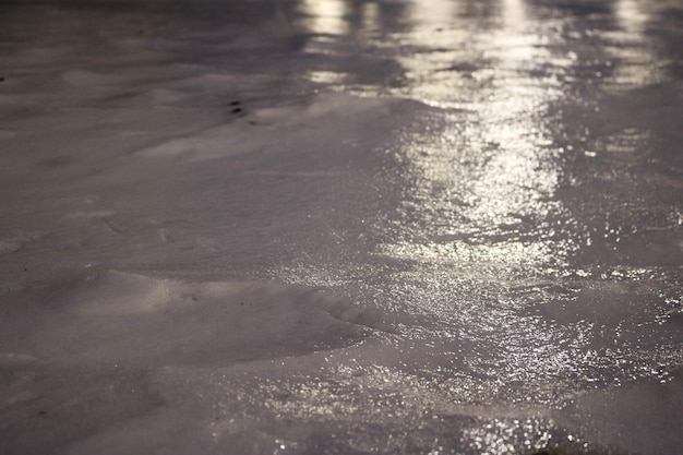 Foto la crosta di ghiaccio luccicante con riflessi di luce che ricopre la fredda neve bianca di notte