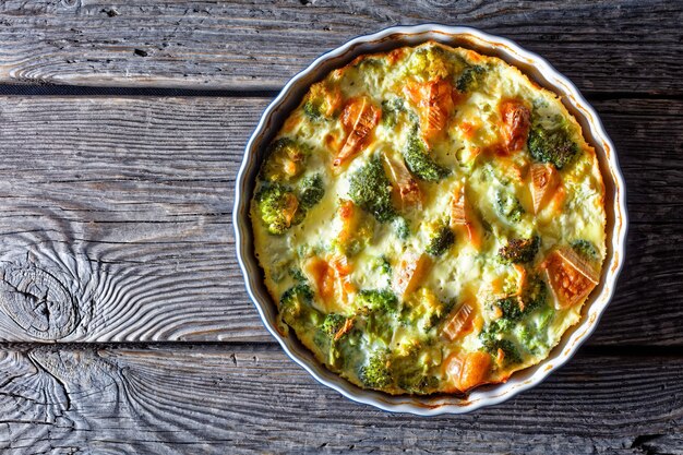 Crustless broccoli quiche gluten free baked with brie and\
cheddar cheese, horizontal view from above, flat lay