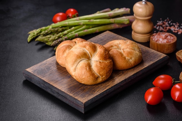 Crusty round bread rolls known as Kaiser or Vienna rolls on a cutting board