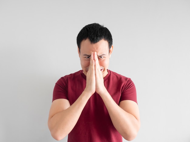 Crying Asian man asking for forgiveness or begging the god for good fortune.