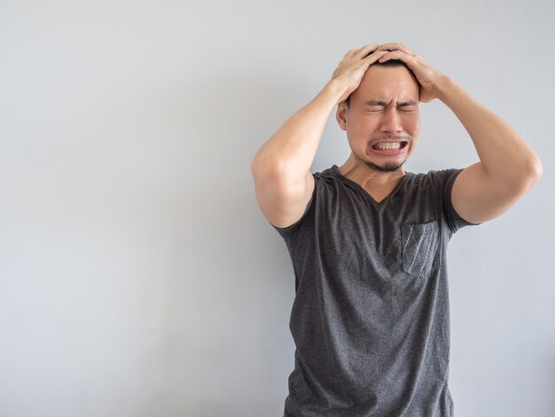 Crying asian man in black t-shirt.