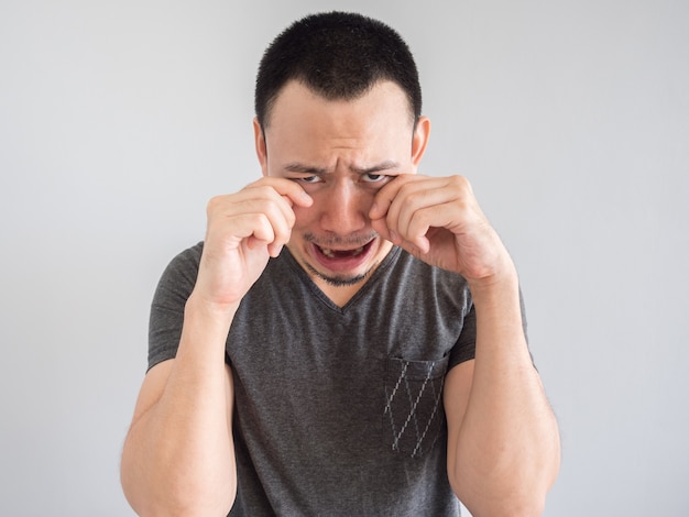 Crying asian man in black t-shirt.