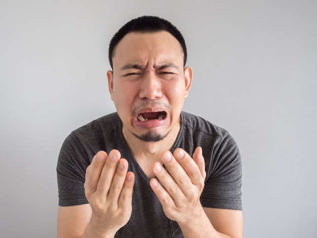 Crying asian man in black t-shirt.