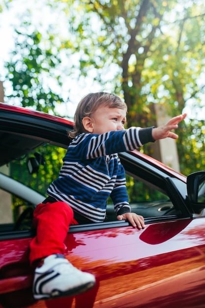 Photo crying baby boy in car.