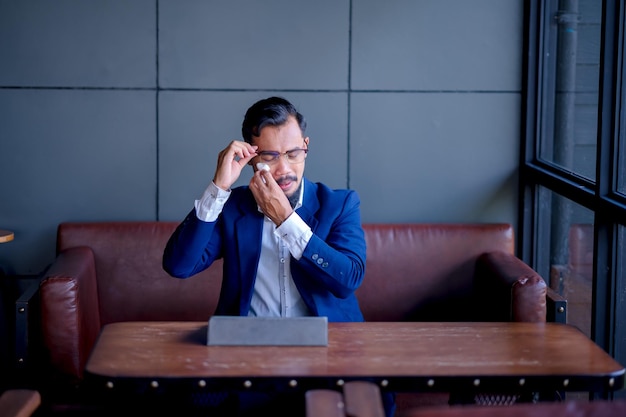 Crying businessman wiping tears with toilet paper