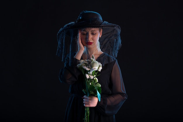 Photo crying female dressed in all black with flowers on black  sadness death funeral