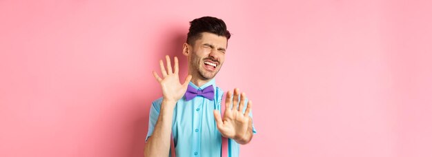 Crying guy asking to stop raising hands up in defense protecting himself from assault standing over