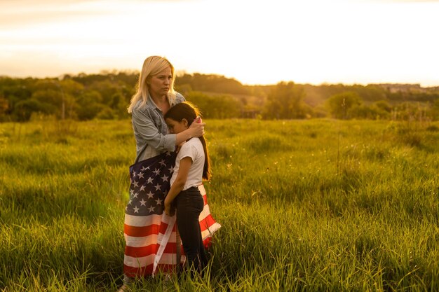 Crying little girl saying goodbye to her military mother outdoors.