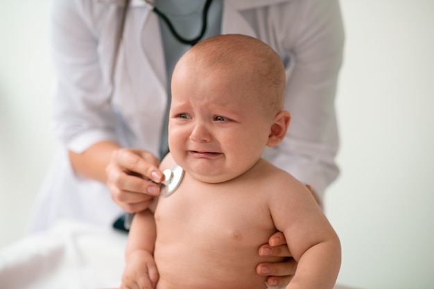 Crying little patient undergoing the chest auscultation