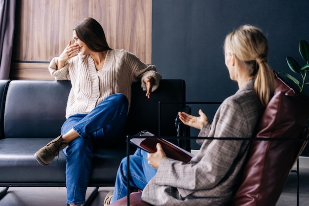 A crying woman in an emotional crisis at a consultation with a psychotherapist