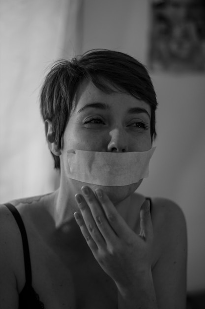 Photo crying woman with duct tape on mouth