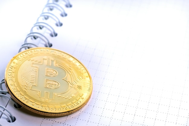 Фото crypto coin bitcoin на бумажном листе открытой спиральной пружинной тетради