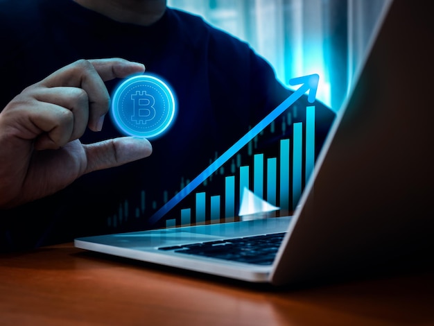 仮想通貨 ビットコイン ビジネスとテクノロジーの背景 ビジネスマンの手にブルーの仮想デジタルビットコインが付いている 仮想成長グラフ 暗い背景の未来的なコンセプト