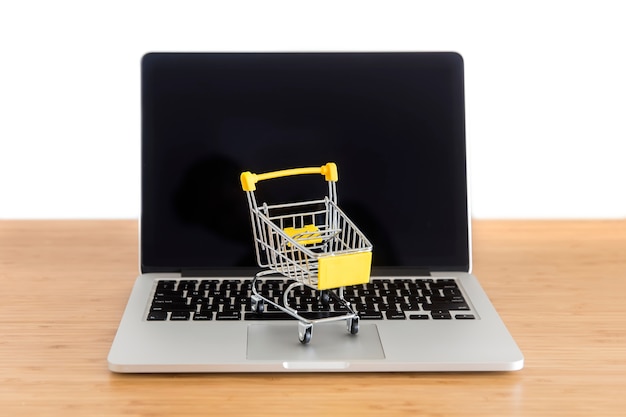 Cryptocurrency bitcoin in mini supermarket trolley on laptop