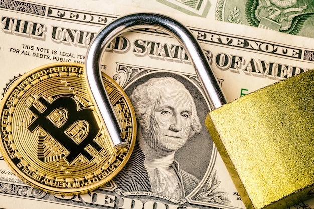 Cryptocurrency bitcoin munt in de buurt van één dollar bankbiljet en geopend hangslot