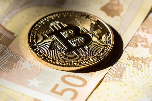 Cryptocurrency coins over euro banknotes Bitcoin coins