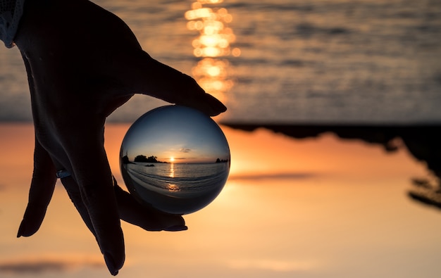 Foto crystal ball riflettendo la sera al tramonto sulla spiaggia