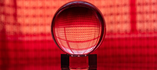 Crystal ball reflecting a red background with checkered details, selective focus.