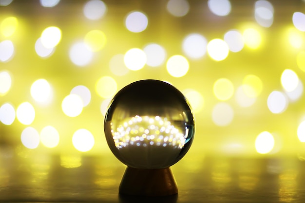 Crystal Ball on the table with bokeh lights behind Glass ball with colorful bokeh light prediction concept