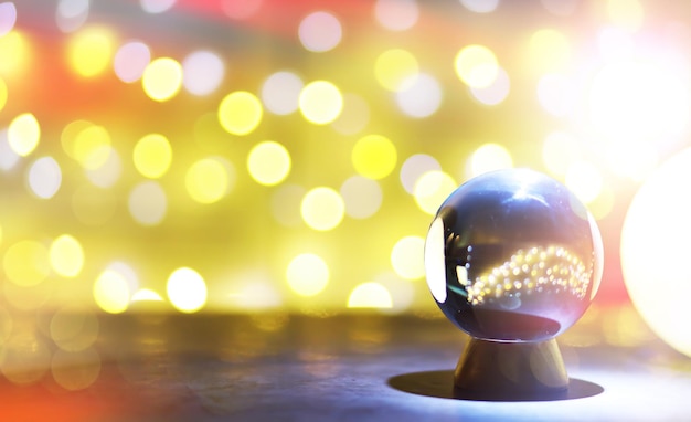 Photo crystal ball on the table with bokeh lights behind glass ball with colorful bokeh light prediction concept