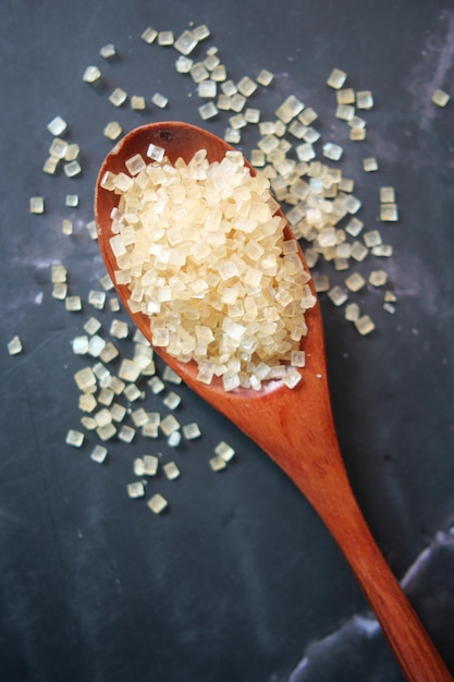 Crystal brown sugar brown on a wooden spoon on table