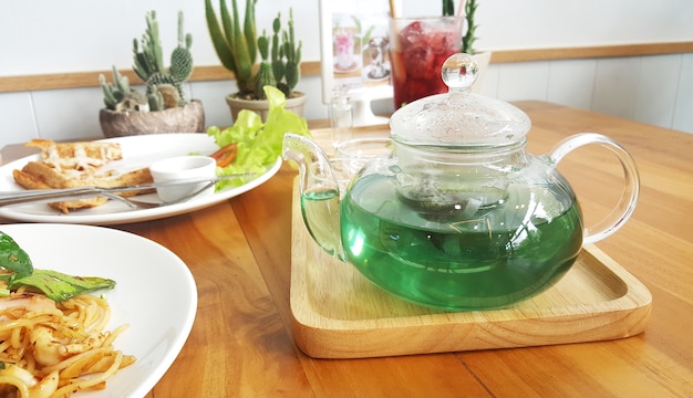 写真 緑色の蝶のエンドウ豆の茶とレモネードとクリスタルクリアティーポット